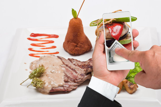 烤牛排和商人使用智能手机在线支付图片下载