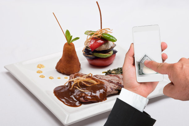 烤牛排和商人使用智能手机在线支付图片下载