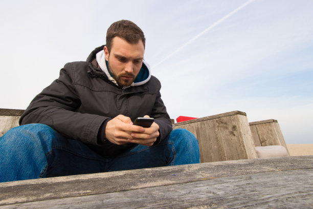 年轻人在户外使用手机的肖像。图片下载