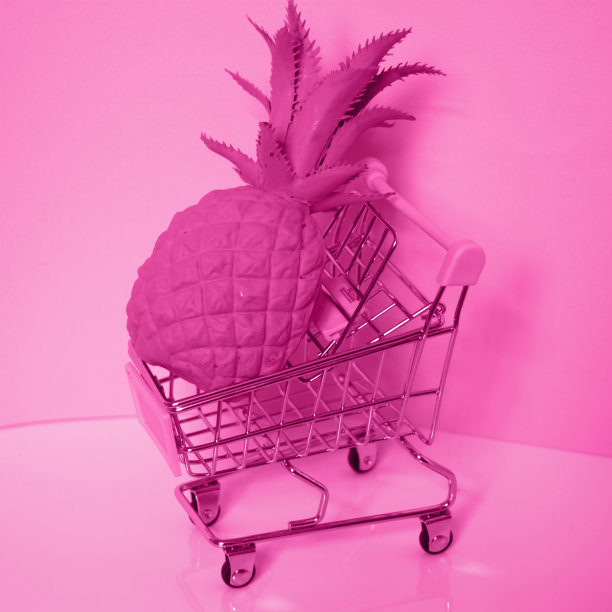 购物车。超市手推车和大菠萝。黑白粉色照片。消费主义的概念图片下载
