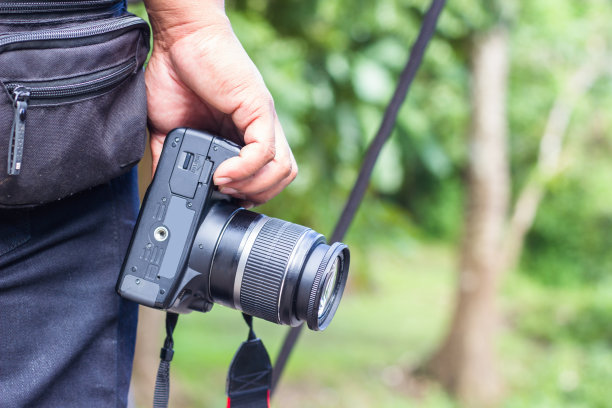 手拿着相机的一边和复制空间。用于书籍封面、宣传册、宣传单的设计。图片下载