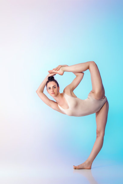 体操运动员在米色泳衣做劈叉图片下载