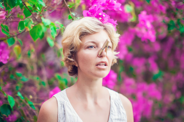 鼻子上戴着衣夹的金发美女。流鼻涕。过敏图片下载