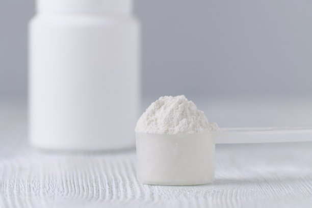 一个白色的勺子和一个灰色的塑料瓶，选择性聚焦图片下载