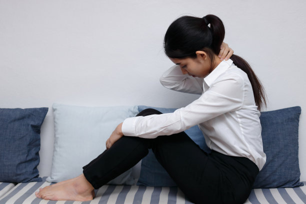 沮丧孤独的年轻亚洲女人坐在客厅的沙发上。图片下载