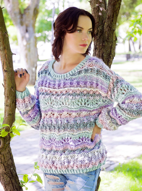 穿着针织毛衣的女人在美丽的公园里摆姿势图片下载