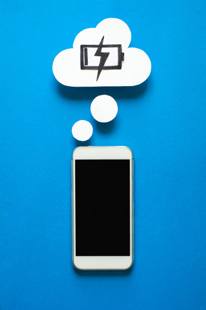 智能手机与纸梦泡泡在蓝色背景。充电时手机做梦。充电的概念。前视图。副本的空间。纸组成图片下载