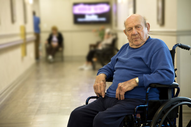 一个坐在轮椅上的老人坐在疗养院里图片下载