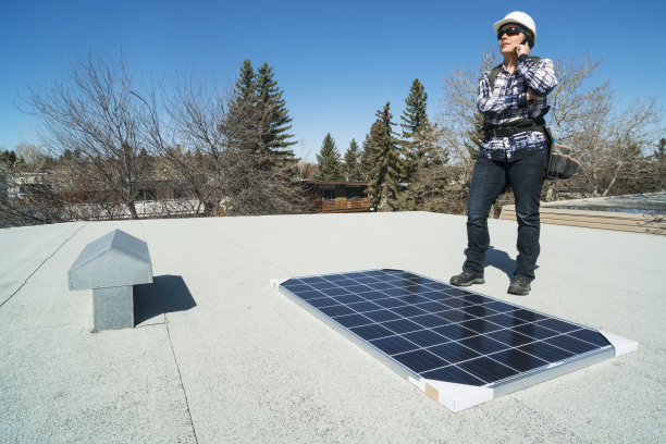 女建筑工人正在安装太阳能电池板图片下载
