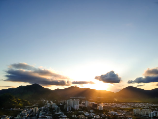 空中风景照片的休闲多斯Bandeirantes海滩在日落时，太阳在山的后面下沉，造成镜头橙色镜头光晕图片下载