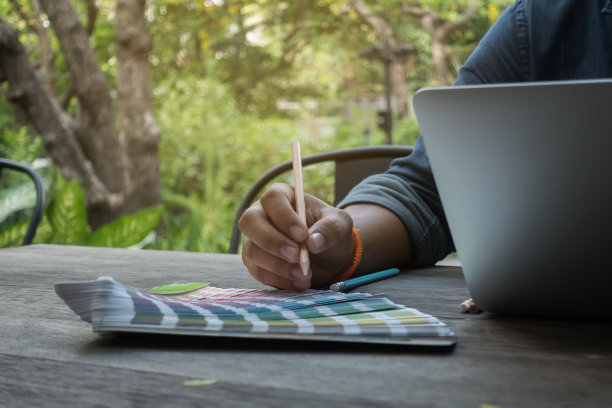 设计师在工作中使用潘通和笔记本电脑图片下载