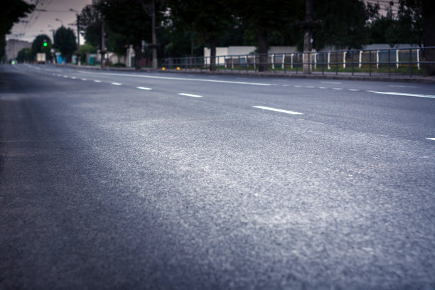 城市道路采用新沥青。沿着它有一个小巷。交通灯和汽车是可见的图片下载