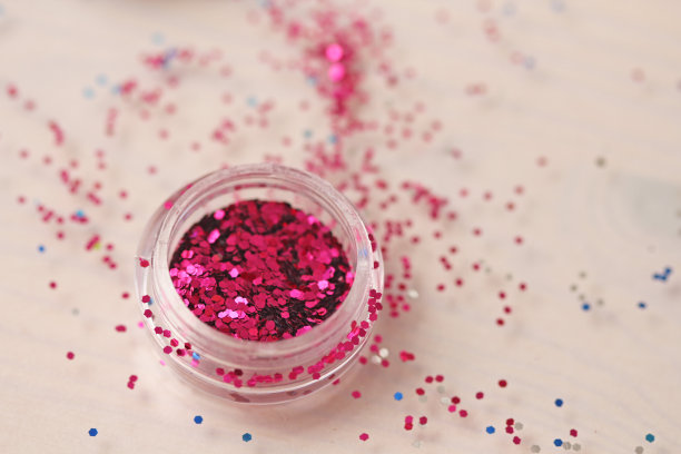 盒子里钉子设计用的粉色亮片。在jar闪闪发光。指甲用锡箔。组照片。闪闪美丽，闪闪发光图片下载