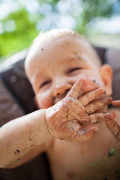 一个一岁的小男孩脸上挂着蛋糕，笑得很开心图片下载