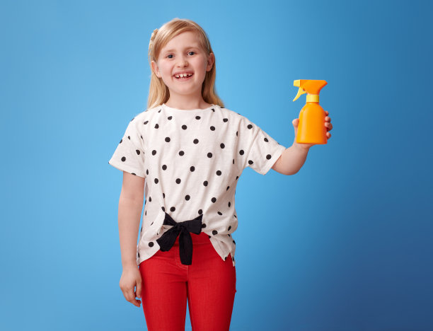 快乐的现代女孩，红色的裤子上的蓝色显示防晒霜图片下载