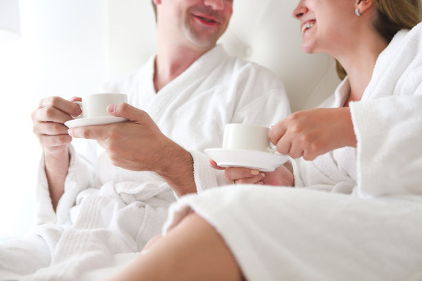 男人和女人穿着浴袍在床上图片下载