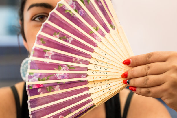 年轻女子拿着亚洲折扇在面前图片下载