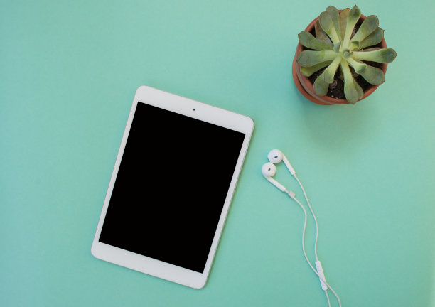 蓝色背景的平板电脑和耳机。图片下载