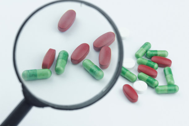 药物，胶囊，片剂，胶囊用放大镜在孤立的白色背景上图片下载