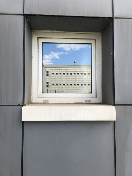 天空和建筑倒映在一扇灰色的窗户上图片下载