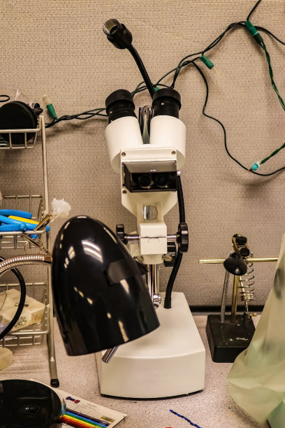 电子实验室桌上放着显微镜，周围放着其他设备。图片下载