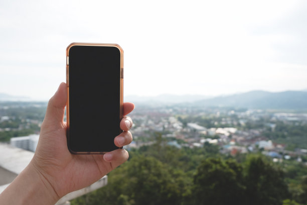 在户外自然环境下，手持智能手机并使用空白桌面屏幕。图片下载