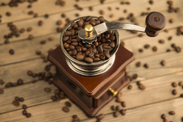 木制背景上的老式咖啡豆研磨机照片。图片下载