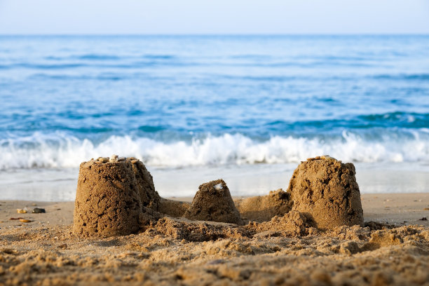 沙滩上的沙堡，以大海和地平线为背景图片下载