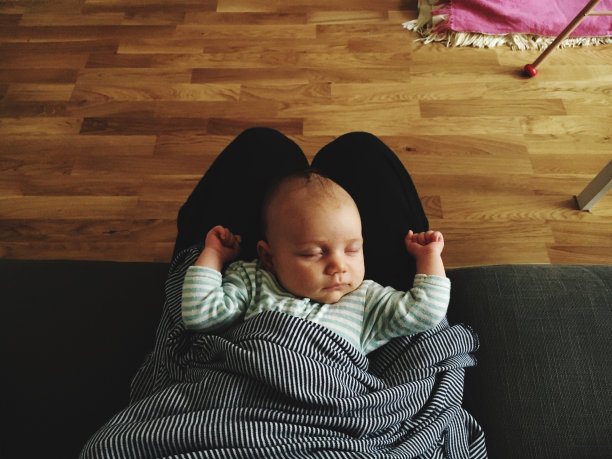 婴儿睡在爸爸腿上的下部图片下载