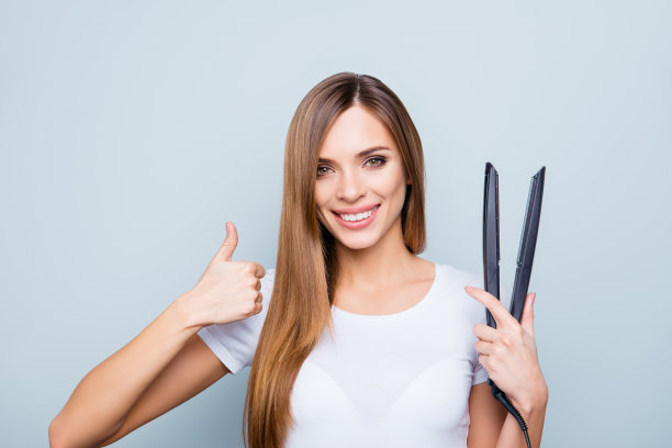 可爱迷人的女孩的肖像有直发在手，显示拇指向上的手指，孤立在灰色背景，看着相机，广告概念图片下载