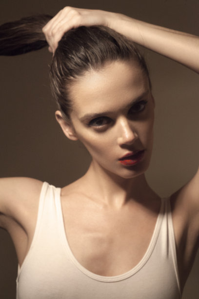 穿白衬衫，手挨着头发的漂亮女孩图片下载