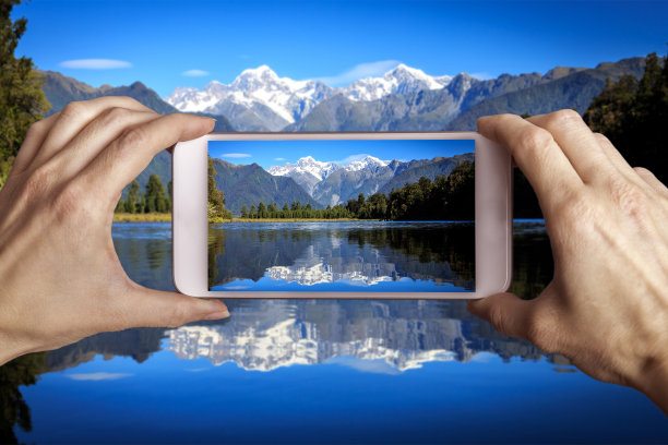 新西兰马西森湖，一名手持手机的女子正在拍照图片下载
