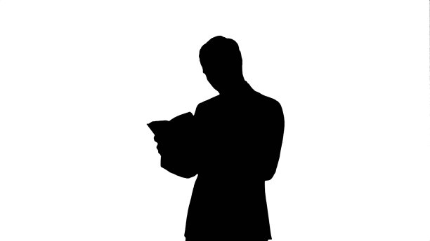 剪影大学学生在笔记本电脑上的书图片下载