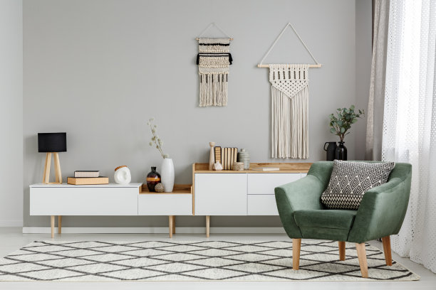 绿色的扶手椅上的图案地毯在明亮的客厅内墙装饰。真实的照片图片下载