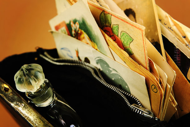 老式香水、文件和明信片装在敞开的旧手提包里图片下载