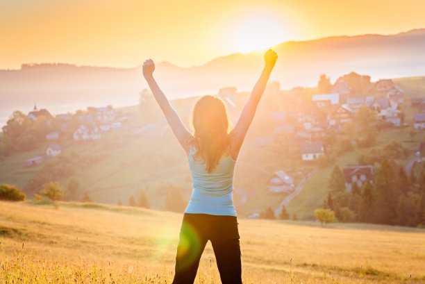 山中快乐的年轻女子。女性在阳光明媚的早晨享受生活。放松的概念图片下载