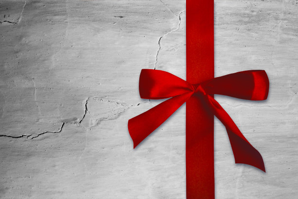 红色的缎带。背景，白色裂缝墙的纹理素材图片