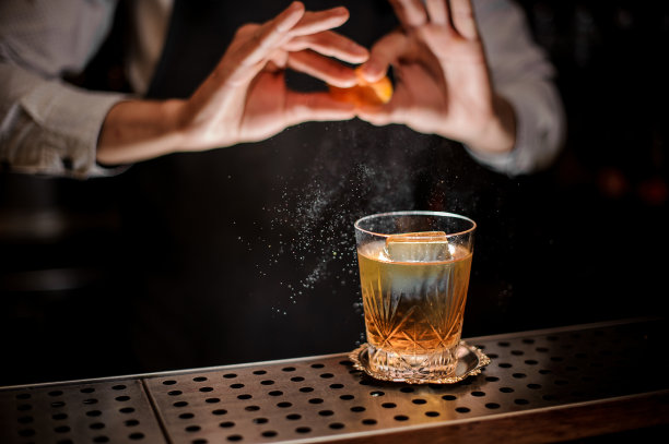 调酒师将橙汁加入到新鲜的酒精饮料中图片下载