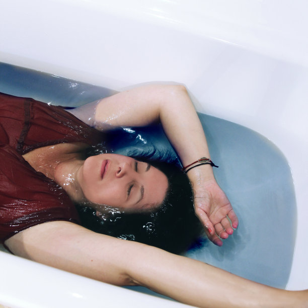 年轻女子躺在浴缸里放松的肖像图片下载