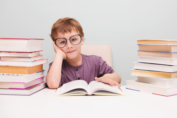 戴着眼镜的学龄前小男孩在看书。图片下载