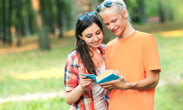 在一个阳光明媚的日子里，在公园里与一本书配对图片下载