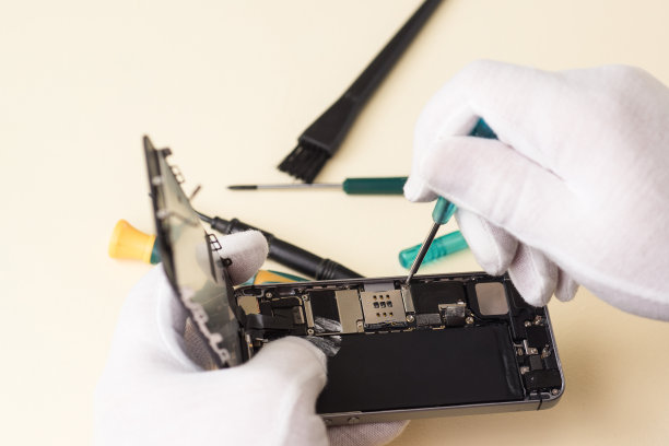 手在白手套与螺丝刀拆卸智能手机图片下载