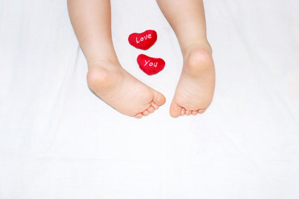 婴儿的脚放在白色的毯子上图片下载