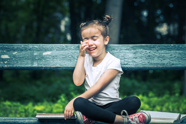 小女孩正坐在长凳上看书图片下载