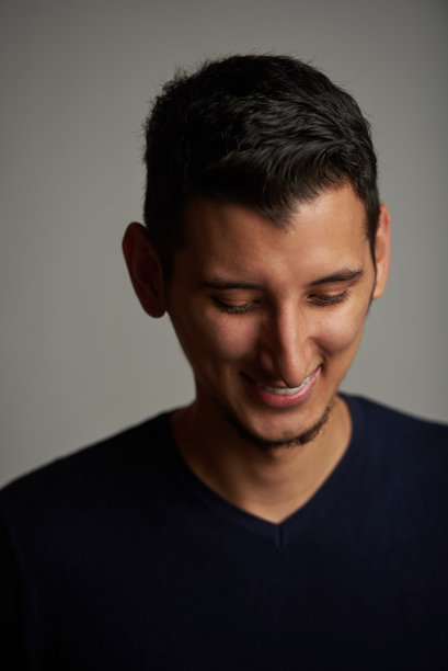 低头微笑的年轻人图片下载