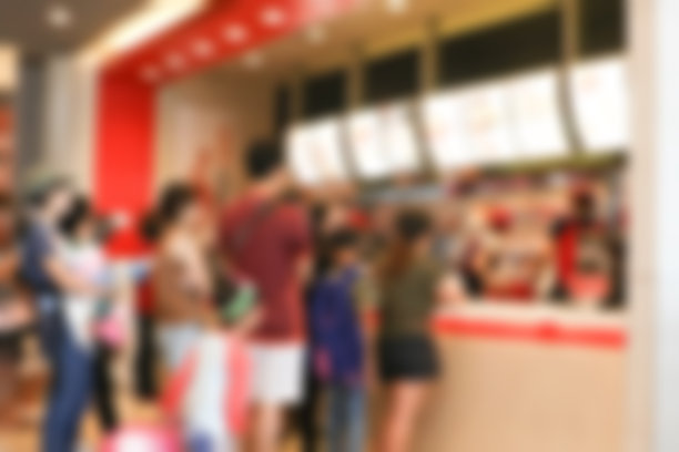 模糊的快餐店背景。生活在城市里的人们在餐馆柜台排队购买食物。图片下载