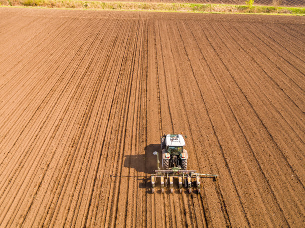 航拍一位农民在地里播种，播种庄稼。图片下载