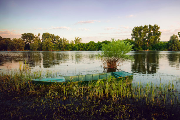 孤独的渔舟漂浮在平静的湖水上。图片下载