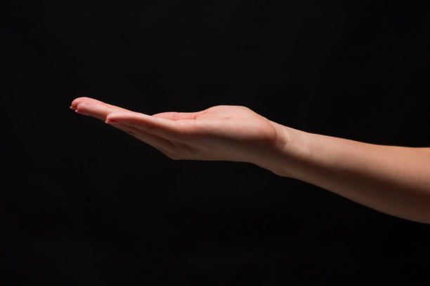 黑色背景下张开手掌的女人图片下载