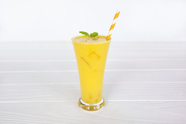 芒果冰沙果汁黄色饮料健康的味道美味的在玻璃饮料插曲早上在白木背景。图片下载
